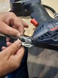 Er wordt gesleuteld aan een handcompressor tijdens het Repair Café van 21 januari jl.